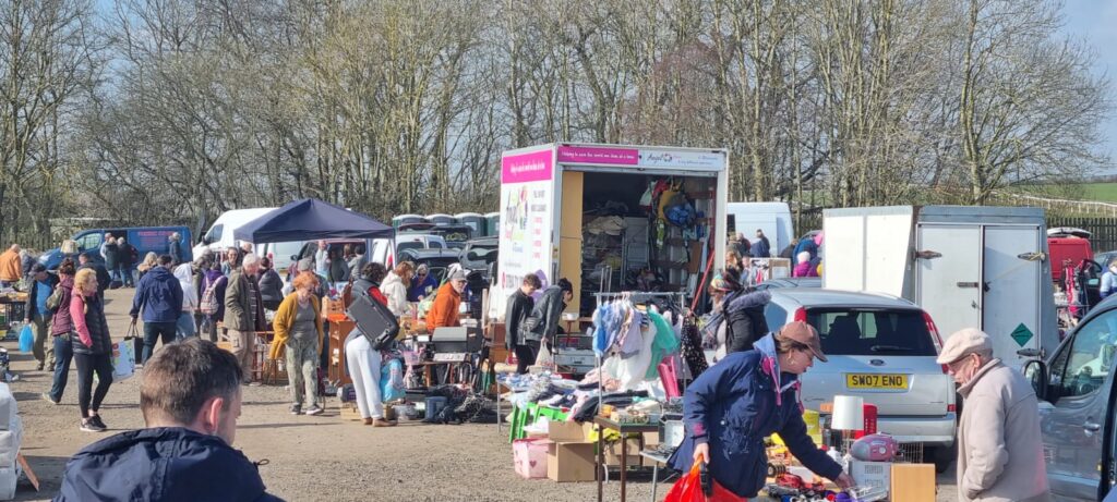 car boot sale with angel house clearance in a grass field